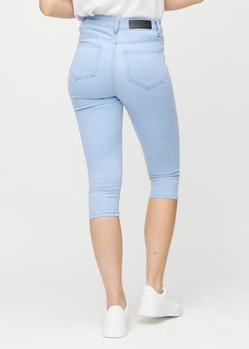 Skinny-Capris für Damen in hellblauem Jeansstoff, Farbe Skies. Rückansicht an einem Model, zeigt die Passform und Gesäßtaschen.