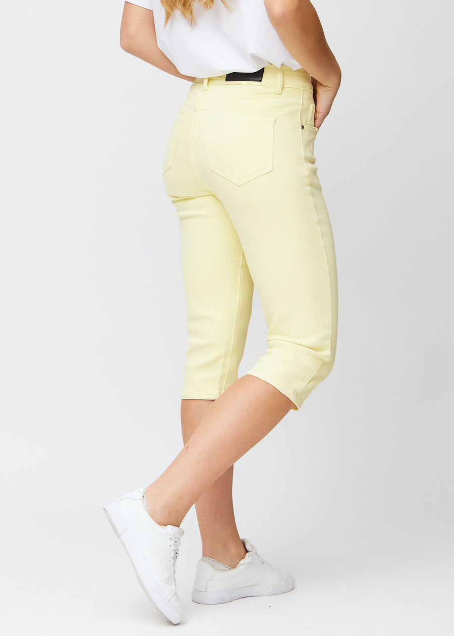 Hellgelbe slim Capris von hinten gesehen, das gesamte Produkt wird am Model mit Fokus auf Passform und Länge gezeigt.