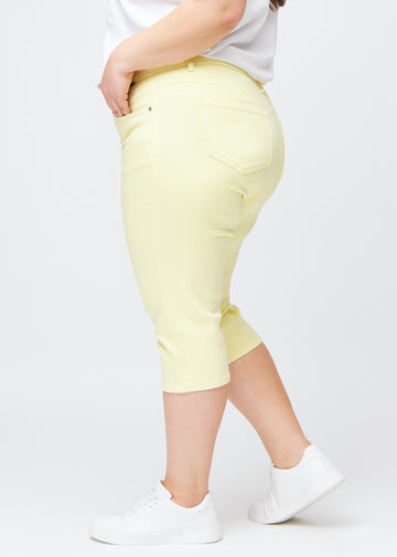 Hellgelbe slim Capris in der Farbe Lemonades, von der Seite an einem Plus-Size-Model gesehen.