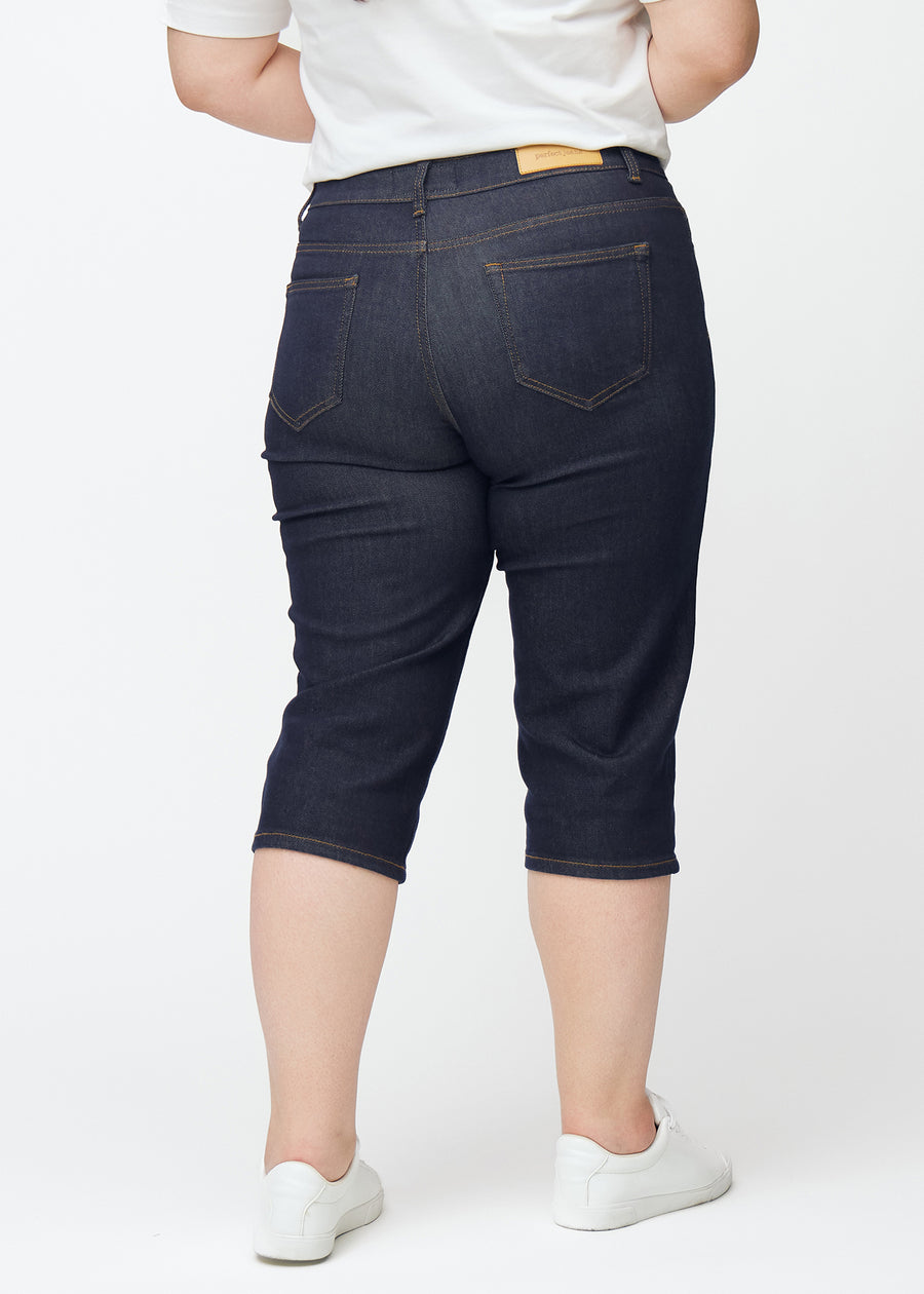 Tief dunkelblaue Denim-Capris für Damen in der Farbe Midnights von hinten auf einem Plus-Size-Model gesehen.