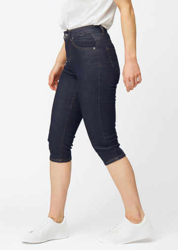 Tief dunkelblaue Denim-Capris für Damen in der Farbe Midnights mit Slim-Passform, von der Seite am Model gesehen.