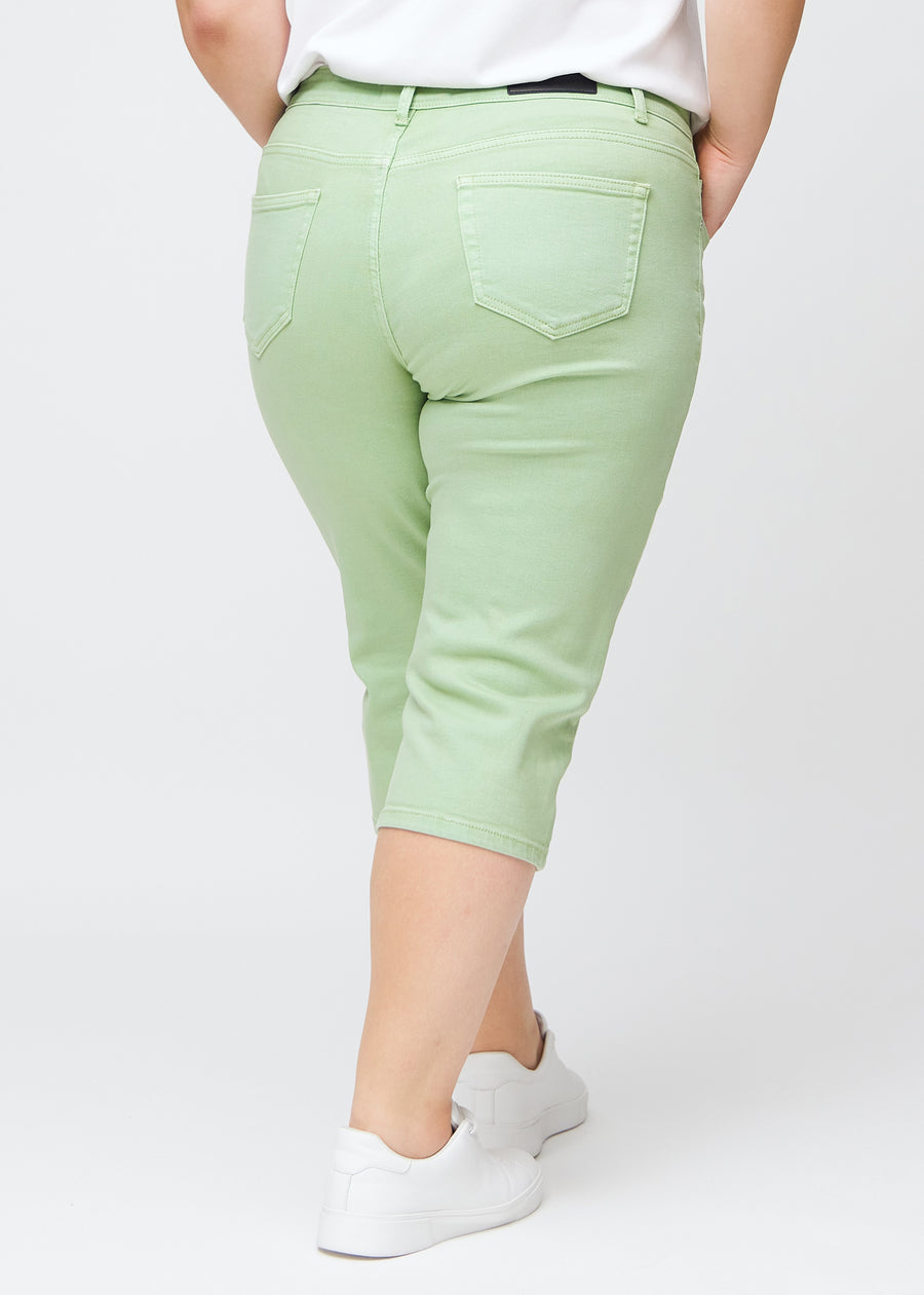 Slim-Capris für Damen aus pastellhellgrünem Jeansstoff, Farbe Mints. Rückansicht an einem Plus-Size-Model, zeigt Passform, Länge und Gesäßtaschen.