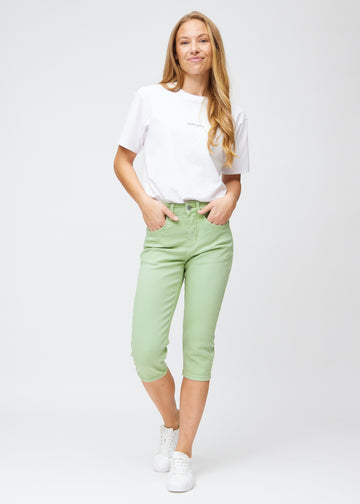 Slim-Capris für Damen aus pastellhellgrünem Jeansstoff, Farbe Mints. Ganzkörperansicht eines Models in den Slim-Capris.
