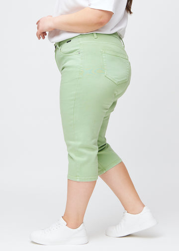Slim-Capris für Damen aus pastellhellgrünem Jeansstoff, Farbe Mints. Seitenansicht an einem Plus-Size-Model, figurbetonter Schnitt und mittelhoher Bund (Mid Rise).