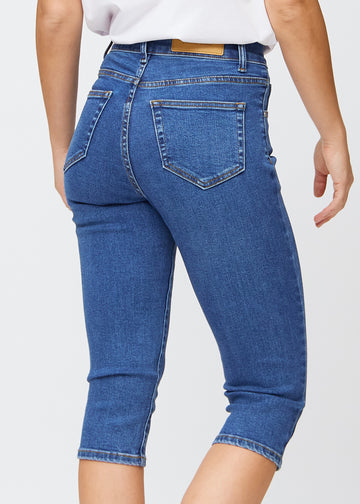 Slim-Capris für Damen aus dunkelblauem Denim, Farbe Oceans. Nahaufnahme von hinten an einem Model, zeigt Taschen und Nähte.