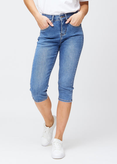 Blaue Denim-slim-Capris, Farbe Rivers, mit enger Passform, die die Beine formt und direkt unter dem Knie endet, von vorne gesehen.