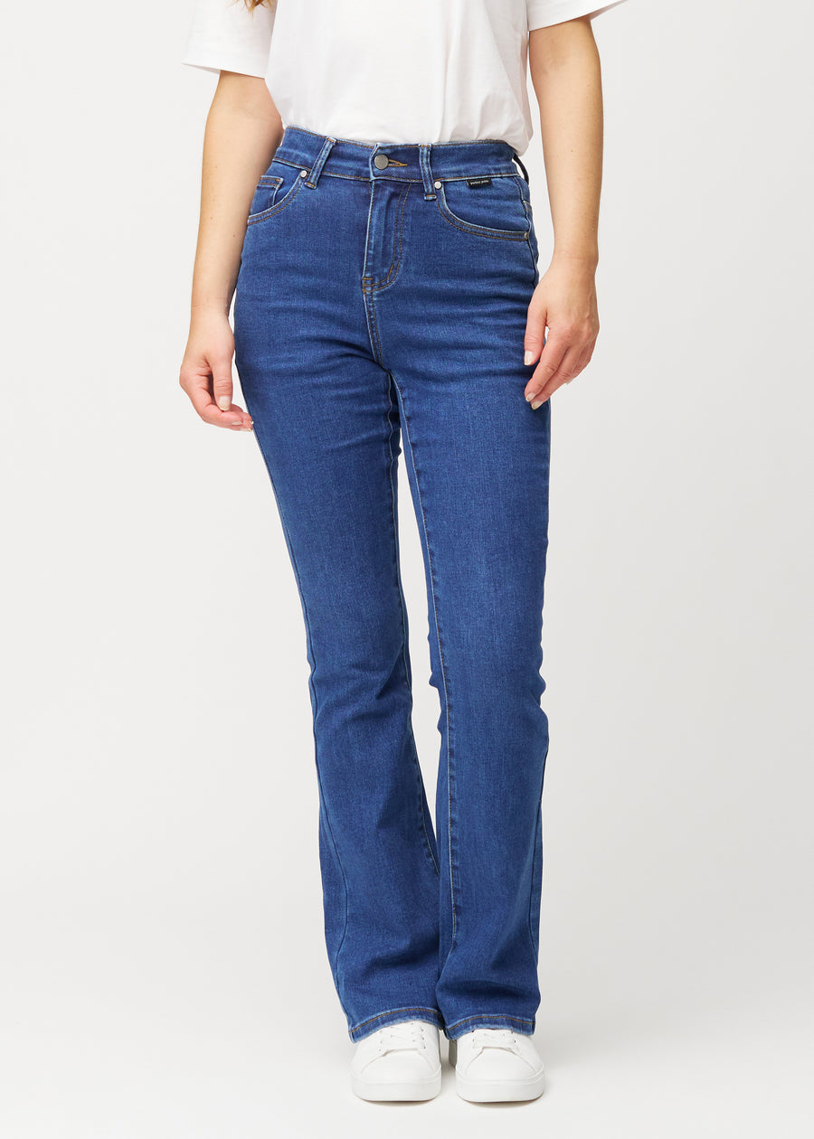 Dunkelblaue Mid-Rise-Bootcut-Jeans in der Farbe Oceans. Vorderansicht an einem Model, an Hüfte und Oberschenkeln anliegend mit leicht ausgestelltem Bein.