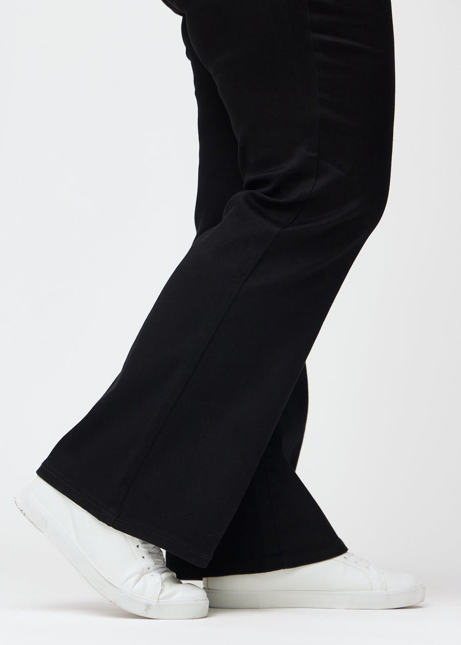 Die Knöchel eines Plus-Size-Models, damit man die leichte Ausstellung am Hosenbein in einer Bootcut-Passform sehen kann.