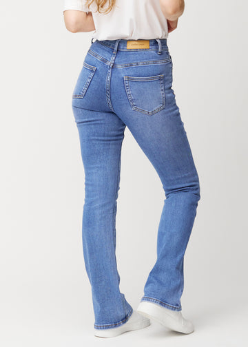 Blaue Mid-Rise-Bootcut-Jeans in der Farbe Rivers. Rückansicht an einem Model, die gesamte Passform ist zu sehen.