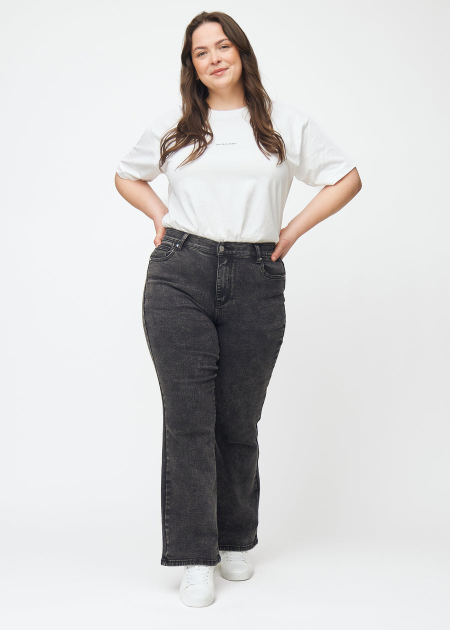 Dunkelgraue Mid-Rise-Bootcut-Jeans in der Farbe Shadows. Ganzkörperansicht eines Plus-Size-Model in den Jeans.