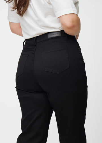 Schwarze hochtaillierte regular jeans von hinten in Nahaufnahme an einem Plus-Size-Model, um Details zu zeigen.
