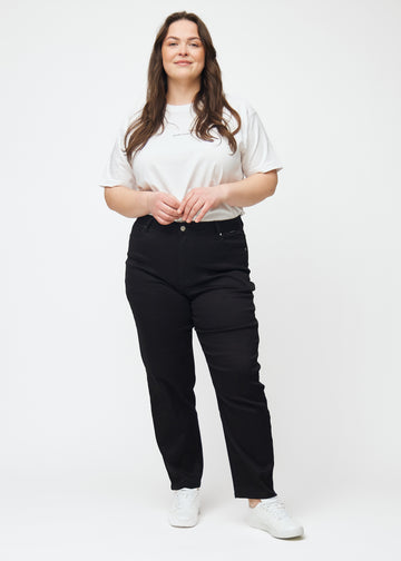 Ganzkörperbild eines Plus-Size-Models in schwarzen hochtaillierten regular jeans.