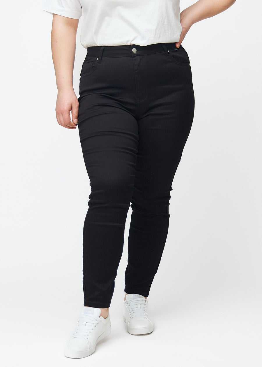 Ein Plus-Size-Model präsentiert schwarze High-Rise-skinny jeans für Damen in der Farbe Ravens von vorne.