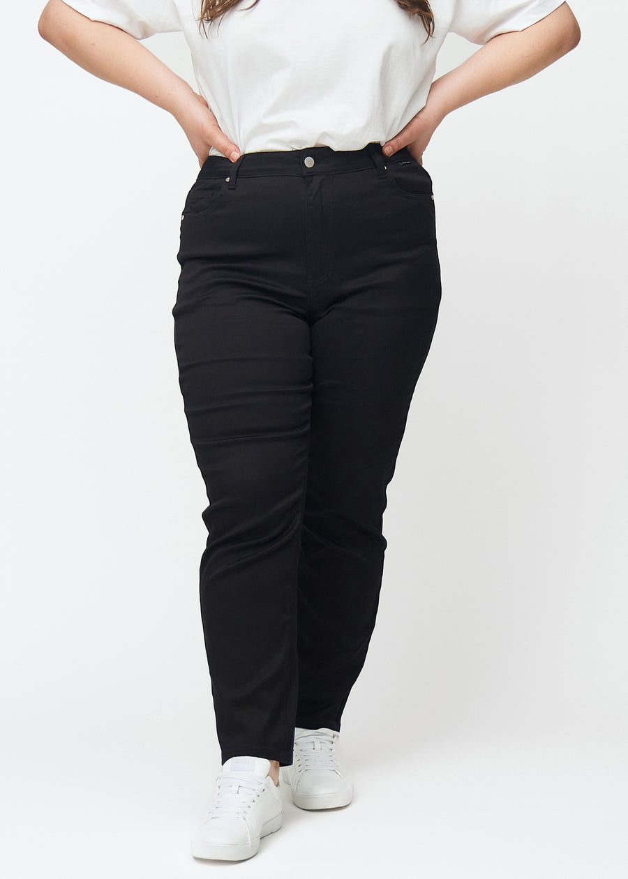 Schwarze hochtaillierte slim jeans, Modellname Ravens, die am Bein eng anliegen, jedoch am Knöchel etwas lockerer sind, an einem Plus-Size-Model, von vorn gesehen.