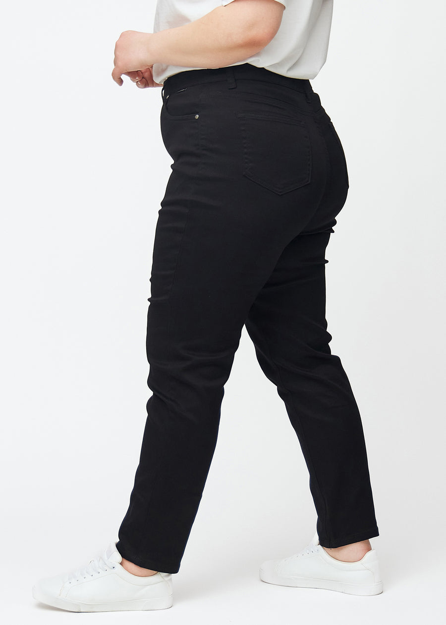 Schwarze hochtaillierte slim jeans von der Seite an einem Plus-Size-Model gesehen.
