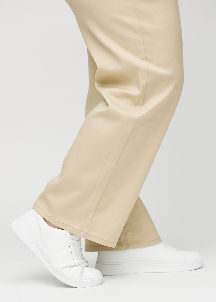 Loose-Jeans für Damen in Beige, Farbe Gazelles. Nahaufnahme an den Knöcheln eines Plus-Size-Models, um die weiten Beinabschlüsse zu zeigen.
