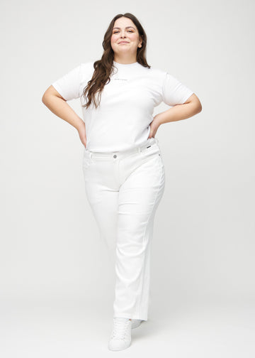 Ganzkörperbild eines Plus-Size-Models in weißen loose jeans.