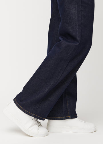 Tief dunkelblaue Denim jeans für Damen in der Farbe Midnights mit loose Passform, nah an den Knöcheln aufgenommen, um den weiten Abschluss zu zeigen.