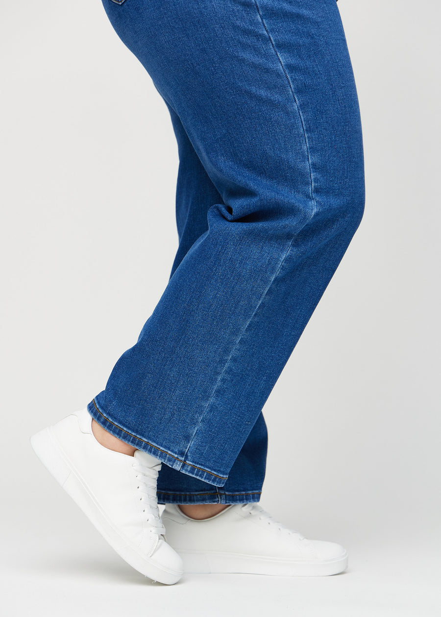 Loose-Jeans für Damen in Dunkelblau, Farbe Oceans. Nahaufnahme an den Knöcheln eines Plus-Size-Models, um die weiten Beinabschlüsse zu zeigen.