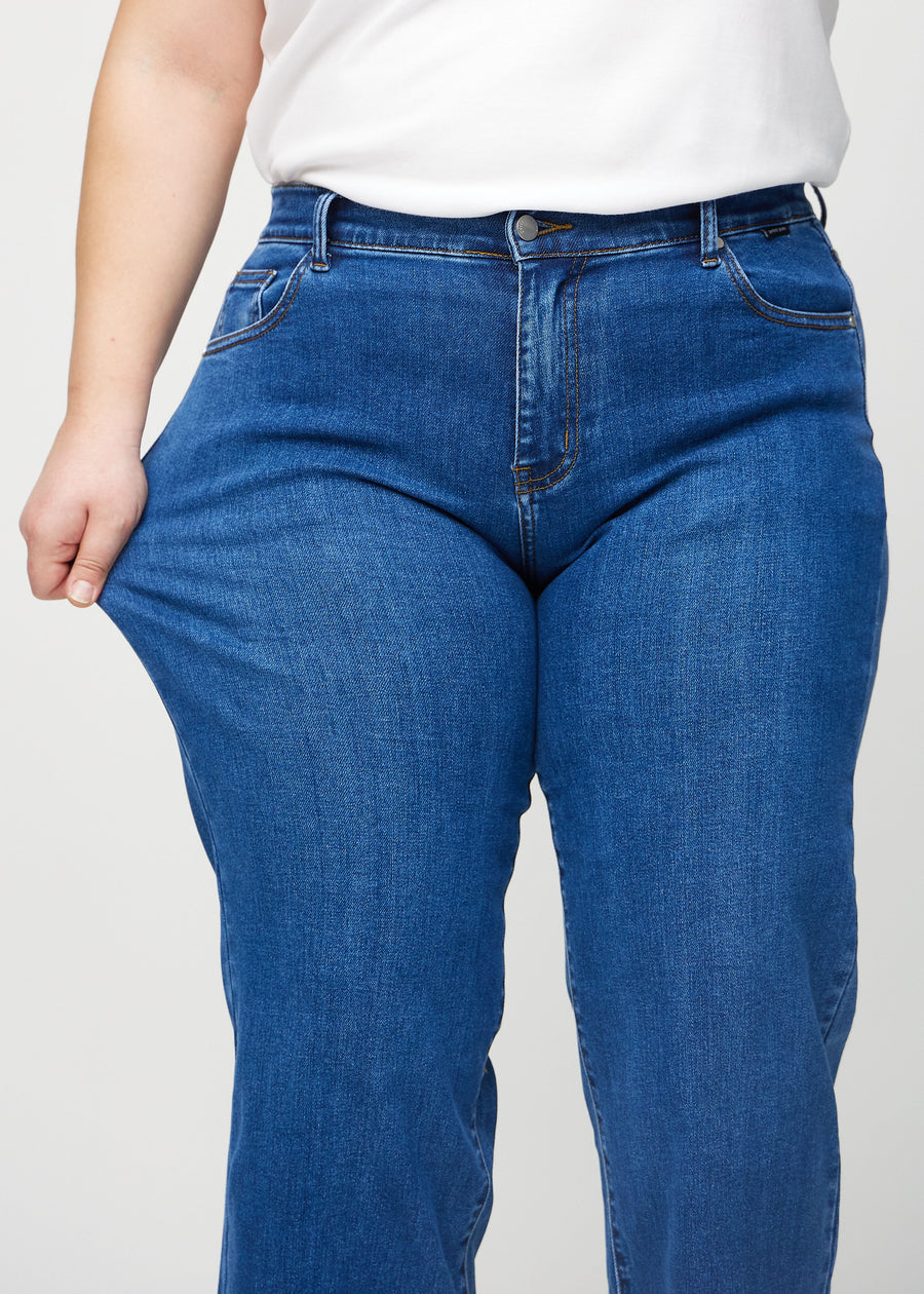 Loose-Jeans für Damen in Dunkelblau, Farbe Oceans. Ein Plus-Size-Model dehnt den Jeansstoff am Oberschenkel, um den Stretch zu zeigen.