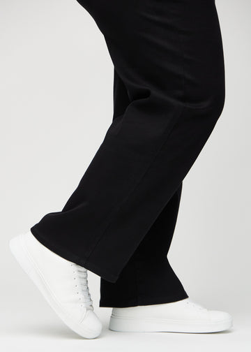 Die Knöchel eines Plus-Size-Models, sodass man sehen kann, wie locker die Jeans in einer Loose Passform sitzt.
