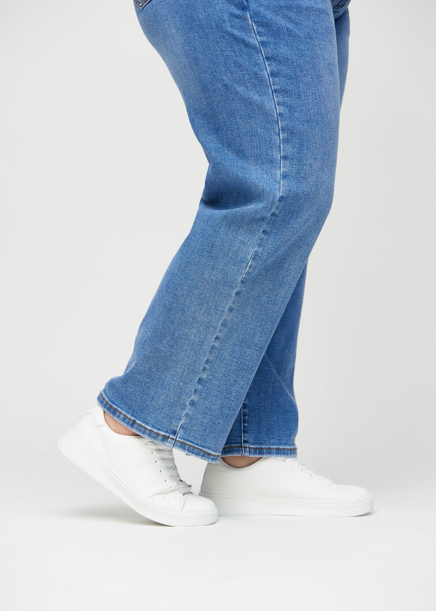 Loose-Jeans für Damen in Blau, Farbe Rivers. Nahaufnahme an den Knöcheln eines Plus-Size-Models, um die weiten Beinabschlüsse zu zeigen.