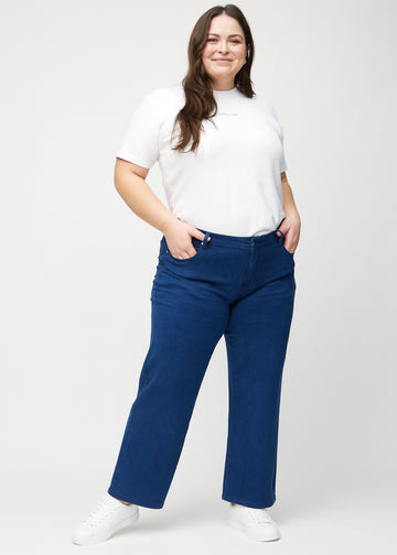 Ganzkörperbild eines Plus-Size-Models in dunkelblauen loose jeans.