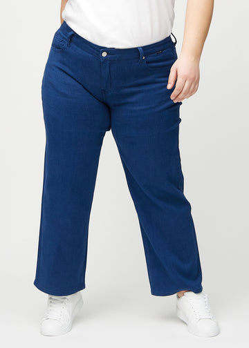 Dunkelblaue loose jeans, Modellname Royals, locker sitzend mit viel Weite in den Beinen an einem Plus-Size-Model, von vorn gesehen.