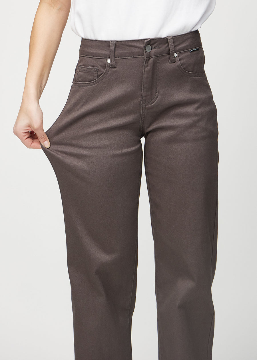 Loose-Jeans für Damen in Graubraun, Farbe Thunders. Ein Model dehnt den Jeansstoff am Oberschenkel, um den Stretch zu zeigen.