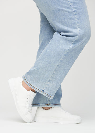 Loose-Jeans für Damen in Hellblau, Farbe Waves. Nahaufnahme an den Knöcheln eines Plus-Size-Models, um die weiten Beinabschlüsse zu zeigen.