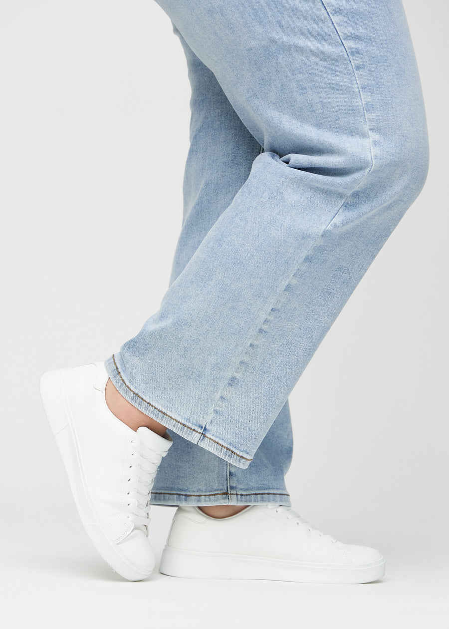 Loose-Jeans für Damen in Hellblau, Farbe Waves. Nahaufnahme an den Knöcheln eines Plus-Size-Models, um die weiten Beinabschlüsse zu zeigen.