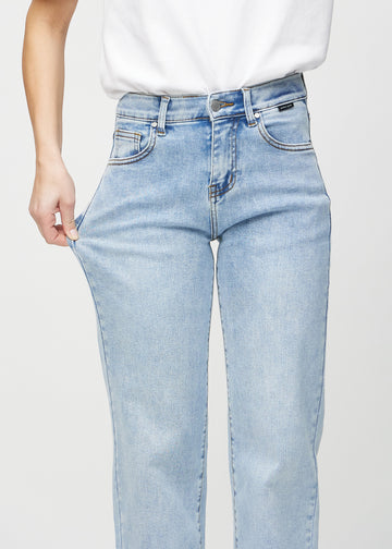 Loose-Jeans für Damen in Hellblau, Farbe Waves. Ein Model dehnt den Jeansstoff am Oberschenkel, um den Stretch zu zeigen.