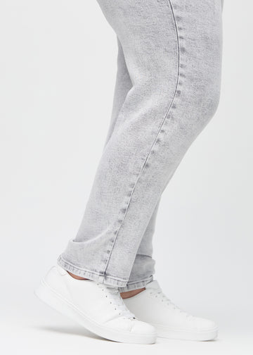 Regular-Jeans für Damen in Hellgrau, Farbe Ashes. Nahaufnahme an den Knöcheln eines Plus-Size-Models, um den geraden Beinabschluss zu zeigen.