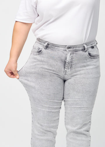 Regular-Jeans für Damen in Hellgrau, Farbe Ashes. Ein Plus-Size-Model dehnt den Stoff am Oberschenkel, um den Stretch zu zeigen.