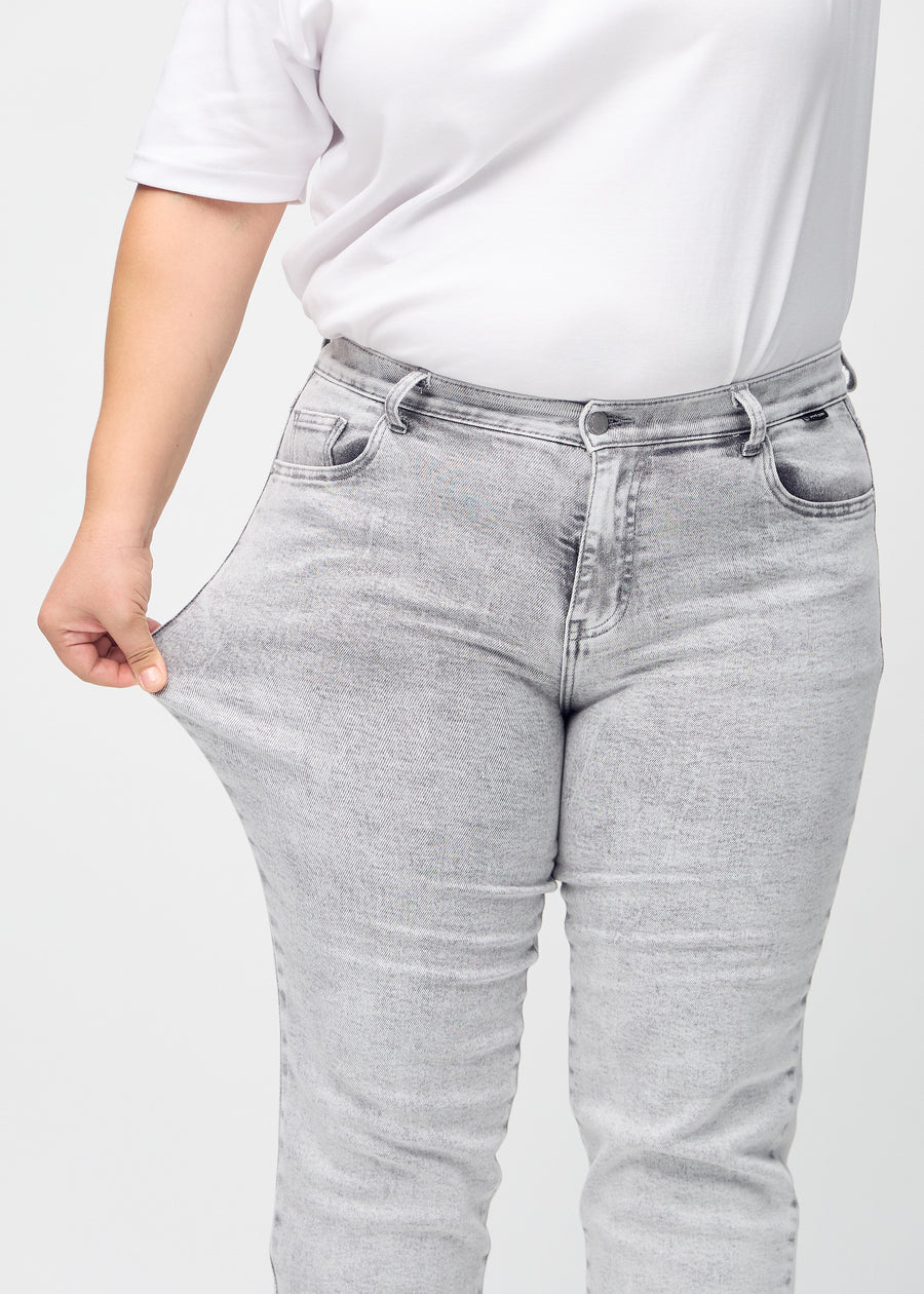 Regular-Jeans für Damen in Hellgrau, Farbe Ashes. Ein Plus-Size-Model dehnt den Stoff am Oberschenkel, um den Stretch zu zeigen.