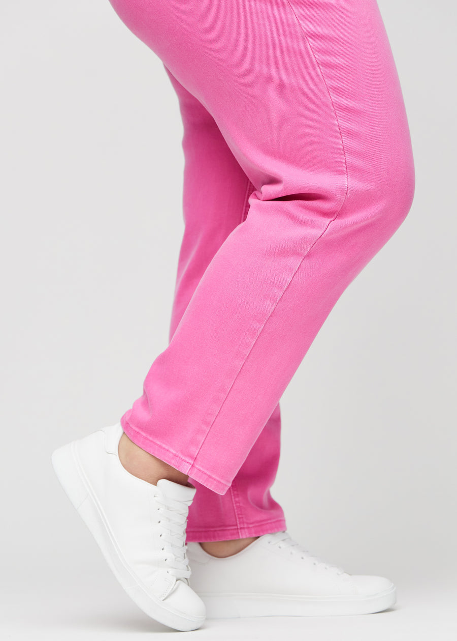 Regular-Jeans für Damen in Hellrosa, Farbe Flamingos. Nahaufnahme an den Knöcheln eines Plus-Size-Models, um den geraden Beinabschluss zu zeigen.