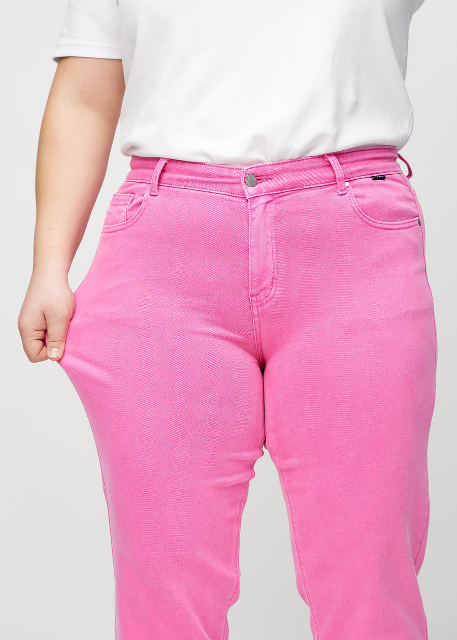 Regular-Jeans für Damen in Hellrosa, Farbe Flamingos. Ein Plus-Size-Model dehnt den Stoff am Oberschenkel, um den Stretch zu zeigen.