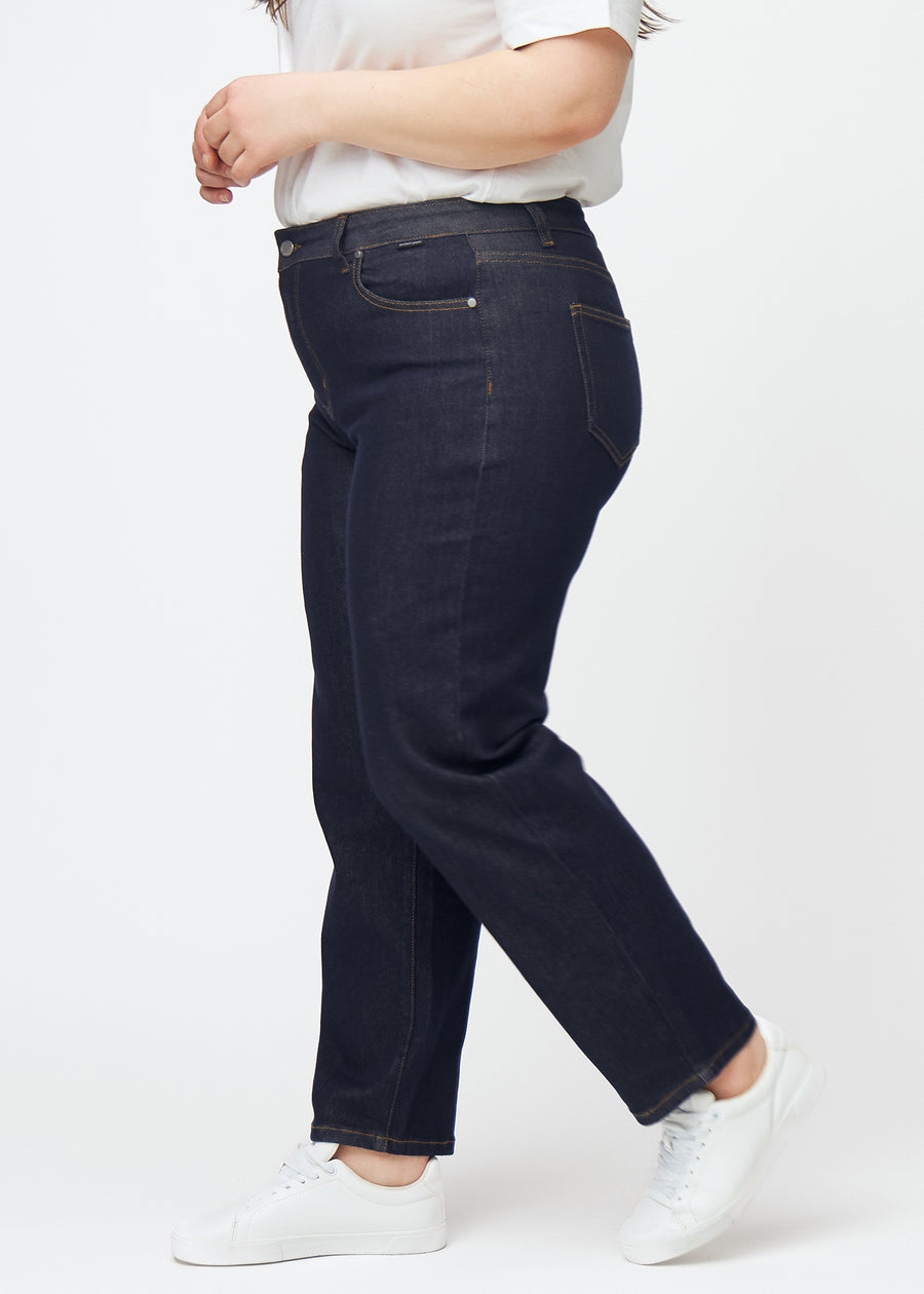 Tief dunkelblaue Denim jeans für Damen in der Farbe Midnights mit regular Passform, seitlich an einem Plus-Size-Model gezeigt.