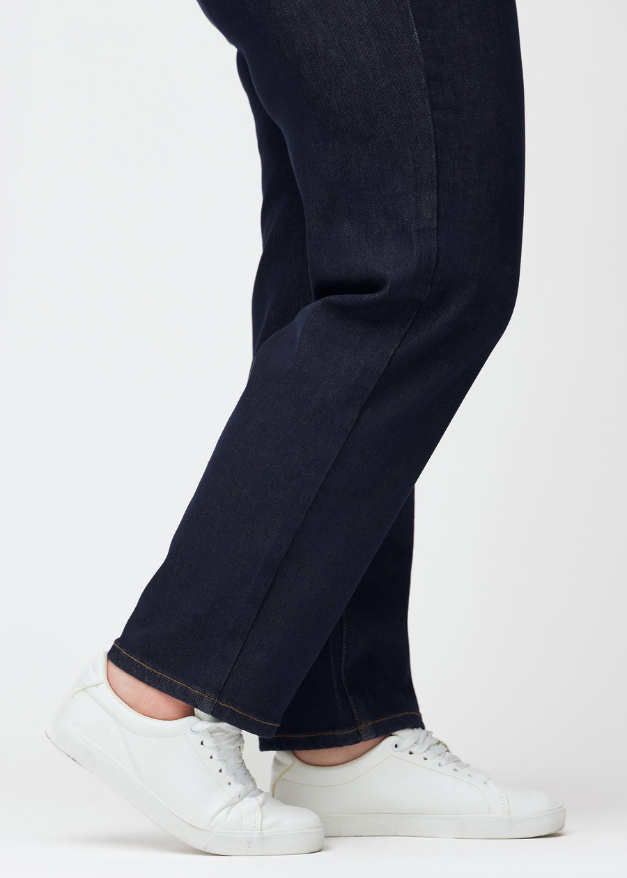 Tief dunkelblaue Denim jeans für Damen in der Farbe Midnights mit regular Passform, in Nahaufnahme an den Knöcheln an einem Plus-Size-Model gezeigt, um den geraden Abschluss zu zeigen.