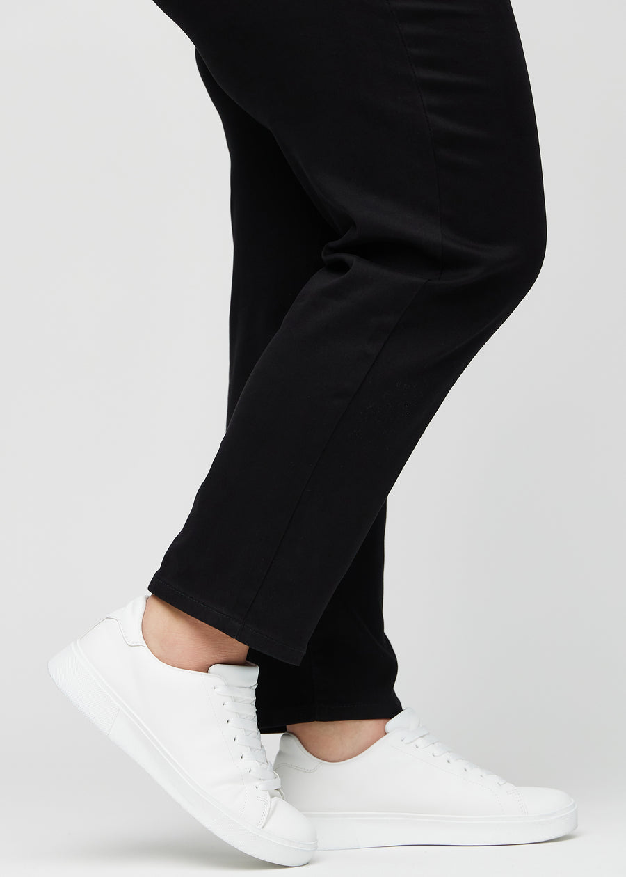 Die Knöchel eines Plus-Size-Models, sodass man sehen kann, wie locker die Jeans in einer Regular Passform sitzt.