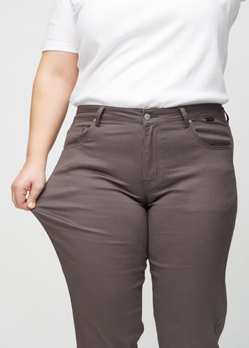 Regular-Jeans für Damen in Graubraun, Farbe Thunders. Ein Plus-Size-Model dehnt den Stoff am Oberschenkel, um den Stretch zu zeigen.