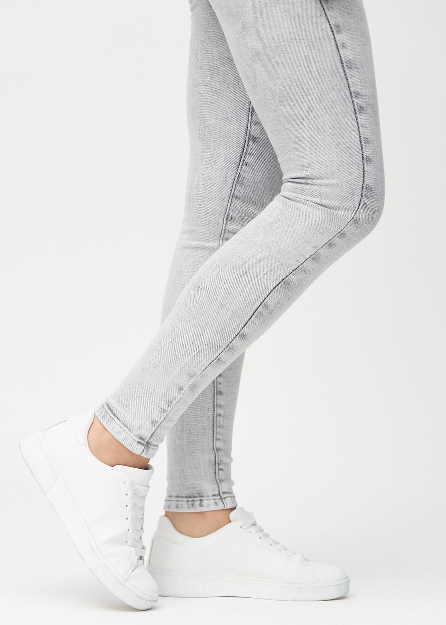 Skinny-Jeans für Damen in Hellgrau, Farbe Ashes. Nahaufnahme der eng anliegenden Beinabschlüsse am Knöchel eines Models.