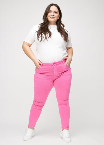 Skinny-Jeans für Damen in Hellrosa, Farbe Flamingos. Ganzkörperansicht eines Plus-Size-Models in den Jeans.
