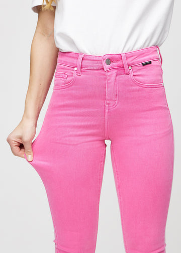 Skinny-Jeans für Damen in Hellrosa, Farbe Flamingos. Ein Model dehnt den Jeansstoff am Oberschenkel, um den Stretch zu zeigen.
