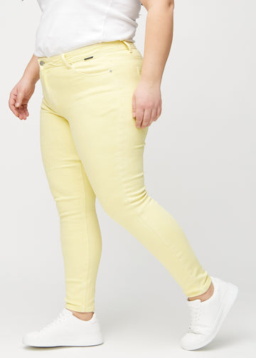Hellgelbe skinny jeans von der Seite an einem Plus-Size-Model gesehen.