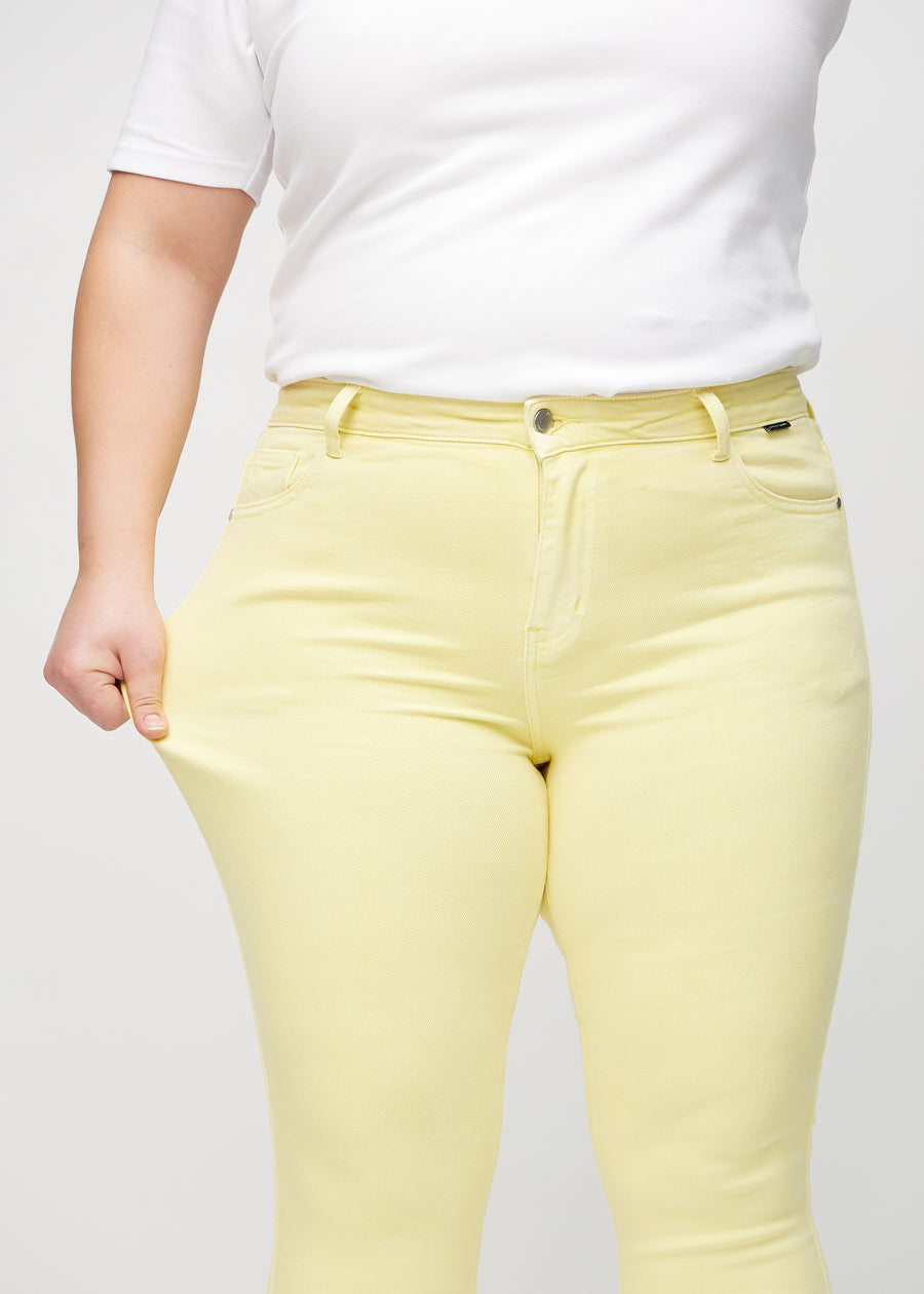 Das Plus-Size-Model zieht die Jeans am Oberschenkel auseinander, um den Stretch zu zeigen.