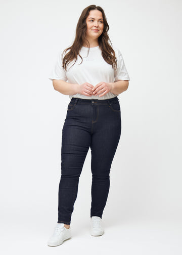 Ganzkörperbild eines Plus-Size-Models in tief dunkelblauer Denim jeans für Damen in der Farbe Midnights mit skinny Passform.