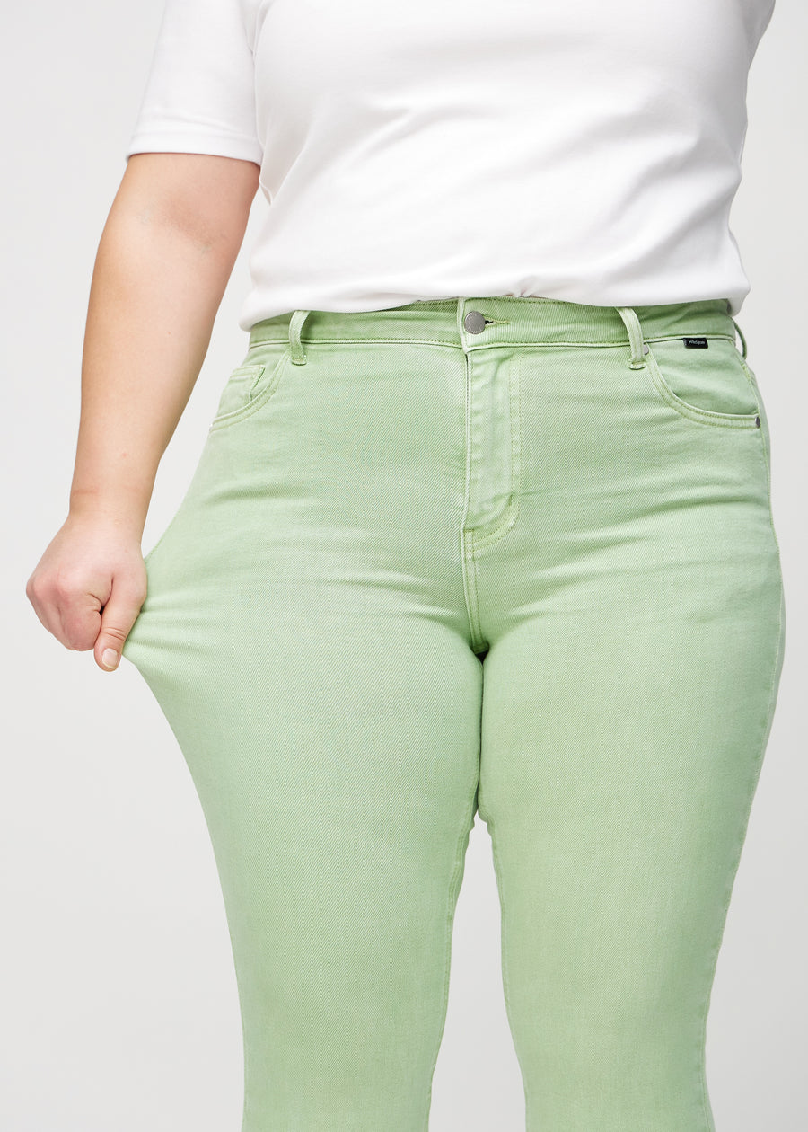 Skinny-Jeans für Damen in Hellgrün, Farbe Mints. Ein Plus-Size-Model dehnt den Jeansstoff am Oberschenkel, um den Stretch zu zeigen.
