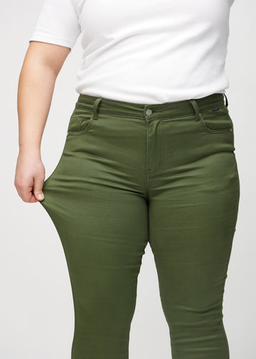 Das Plus-Size-Model zieht die Jeans am Oberschenkel auseinander, um den Stretch zu zeigen.