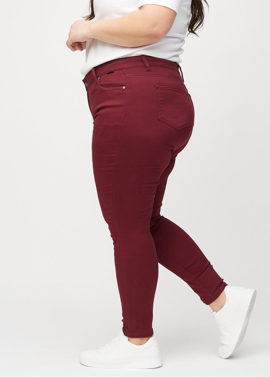 Dunkelrote skinny jeans an einem Plus-Size-Model von der Seite gesehen.